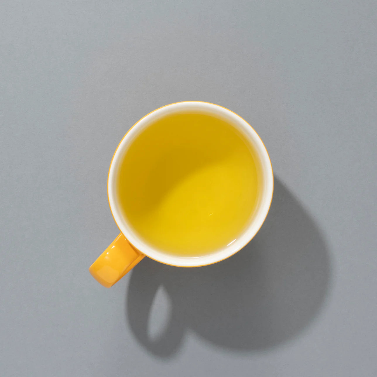This is the brewed chamomile infusion from Suki Tea Makers' Organic Chamomile. The cup showcases a bright golden-yellow liquor, typical of high-quality whole chamomile flowers.