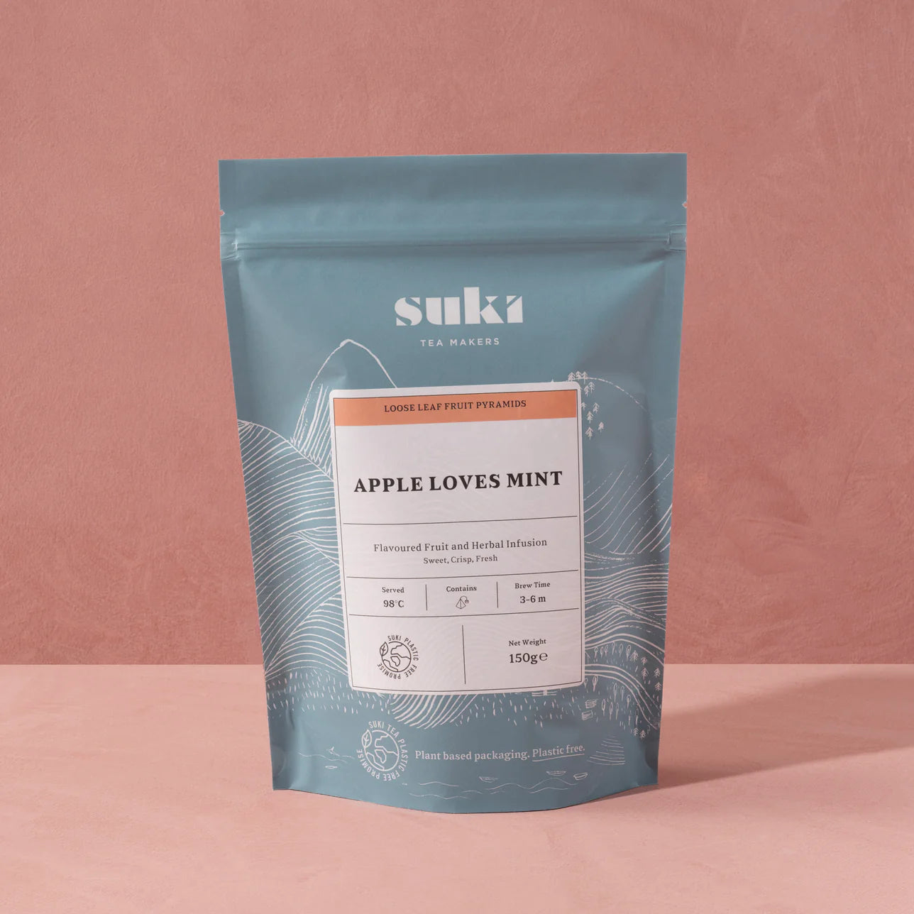 Suki Tea Makers Apple Loves Mint loose leaf tea in a blue resealable pouch with illustrated mountain design, featuring a label describing it as a sweet, crisp, fresh fruit and herbal infusion.