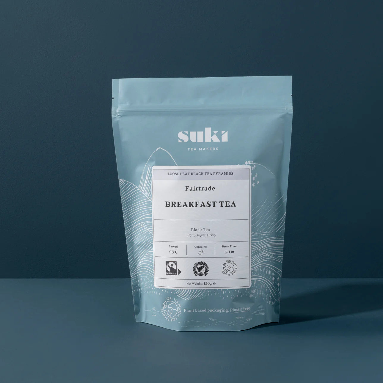 Suki Tea Makers Fairtrade Breakfast Tea in a resealable blue pouch, displayed against a dark blue background.