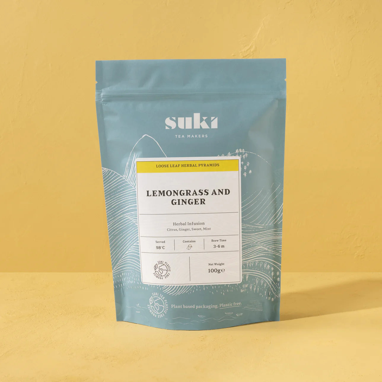 Suki Tea Makers Lemongrass and Ginger herbal infusion pouch on a yellow background.