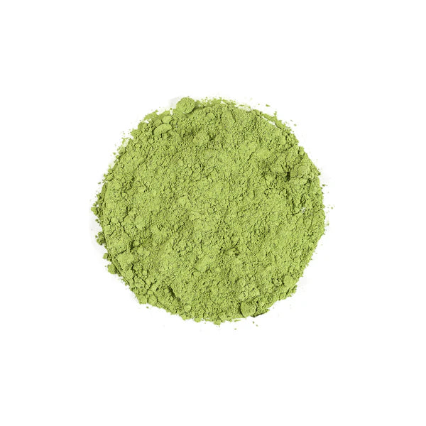 Bright green matcha powder in a loose, circular mound on a white background.